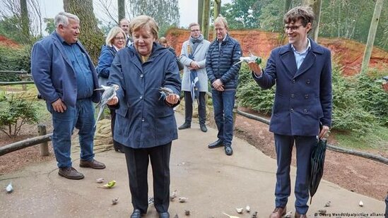 Merkel parkda quşları bəsləyərkən tutuquşunun "hücumuna" məruz qaldı - FOTO