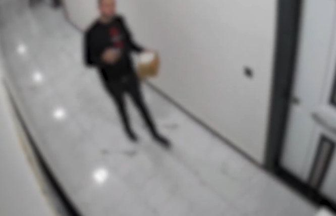 Kuryer şüşə bağlamanı kameraya baxaraq yerə çırpdı